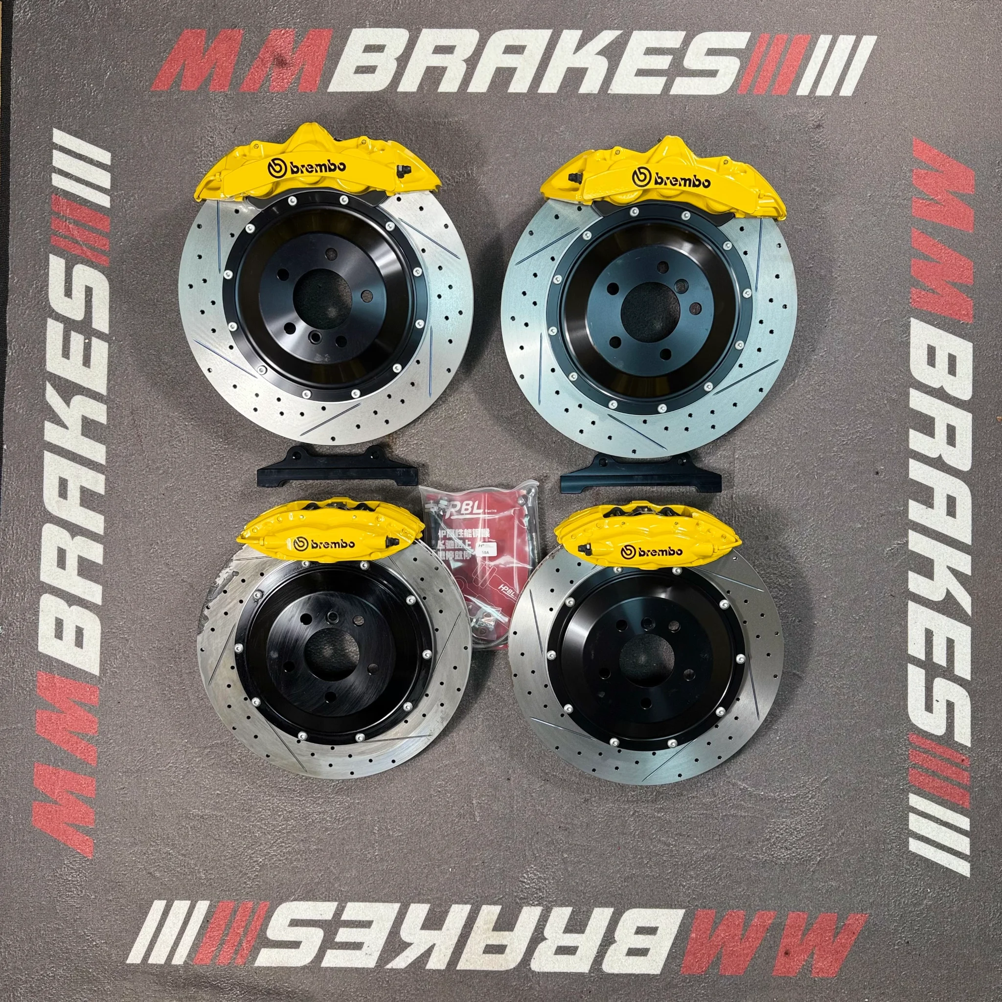 Комплект Brembo GT6 380 и F40 380 для BMW 7: четыре жёлтых суппорта на перфорированных дисках с насечками и чёрными колоколами