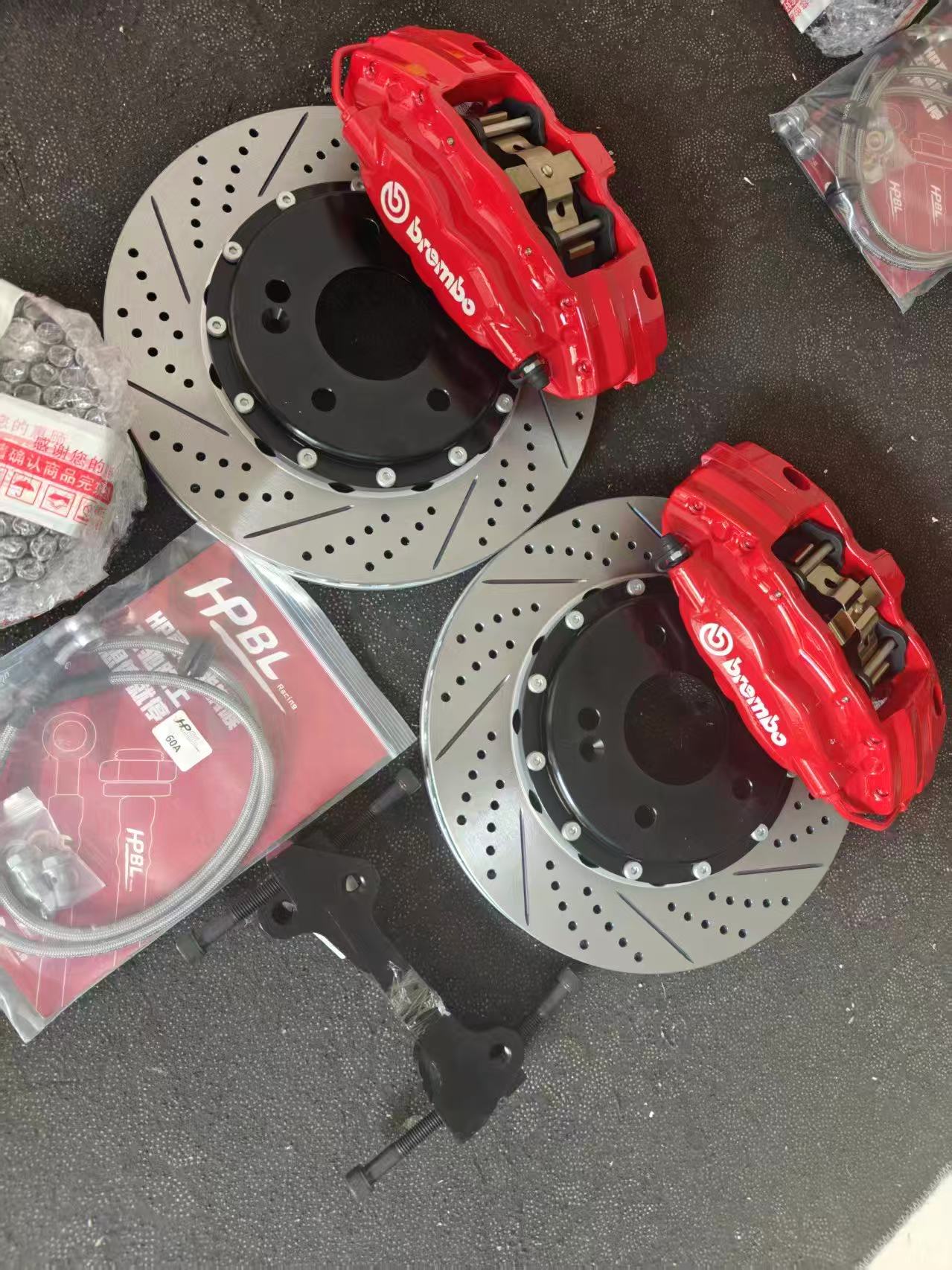Комплект тормозов Brembo с красными четырёхпоршневыми суппортами, перфорированными дисками с насечками и армированными шлангами