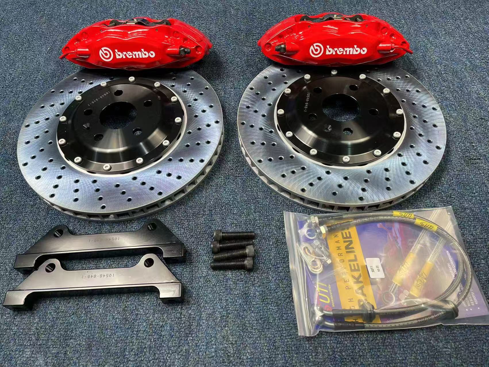 Четырёхпоршневые суппорта Brembo красного цвета с перфорированными двухсоставными дисками, кронштейнами и армированными шлангами