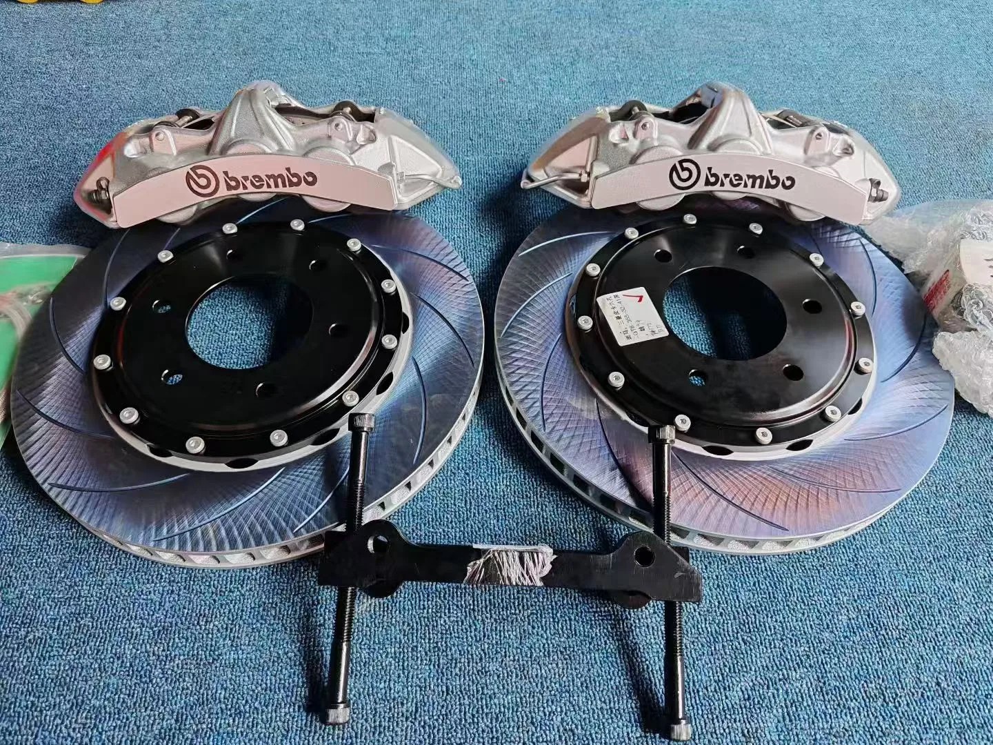 Два шестипоршневых суппорта Brembo серебристого цвета с двухсоставными дисками с насечками и кронштейнами