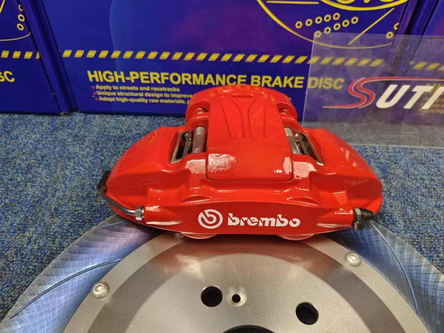 Красный задний суппорт Brembo с логотипом на слотированном тормозном диске с колоколом на болтах